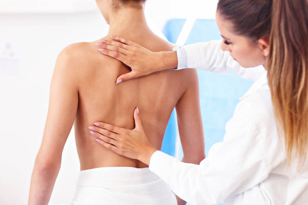 Physiotherapeutin hilft Patientin mit Rückenproblemen in Klinik - Foto, Bild