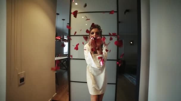 Beautiful and fashionable woman blowing red confetti at camera by hands. - Footage, Video