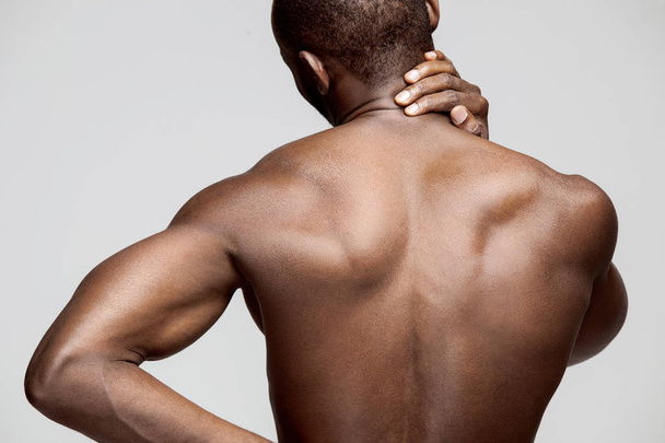 Studio shot of man with pain in neck - Photo, image