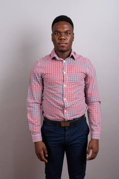 Young African businessman standing against white background - Fotoğraf, Görsel