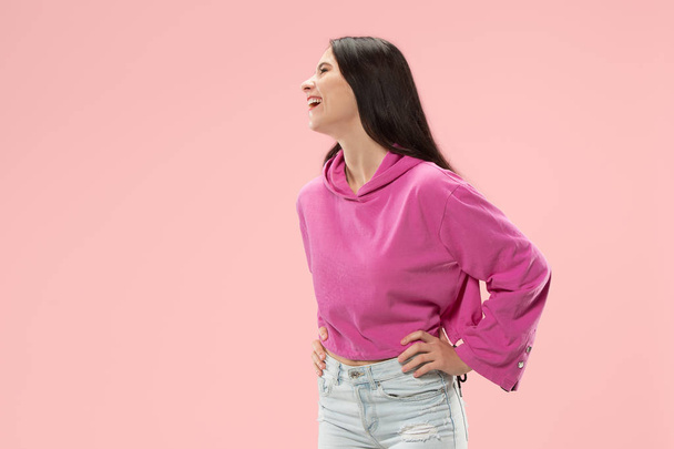 The happy business woman standing and smiling against pink background. - Foto, afbeelding