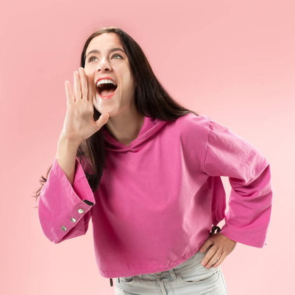 Isolated on pink young casual woman shouting at studio - Foto, Bild