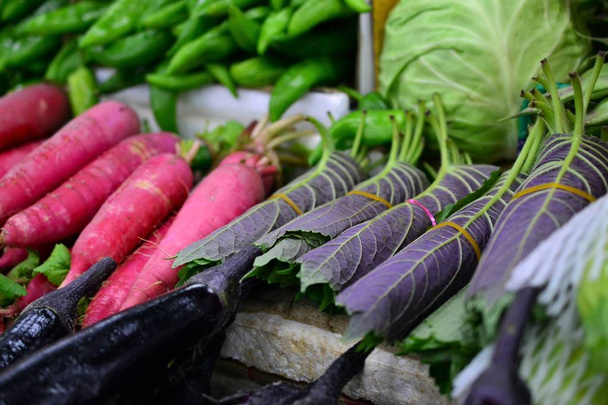 hojas de rábano y sésamo, verduras frescas en el mercado callejero en China
 - Foto, imagen