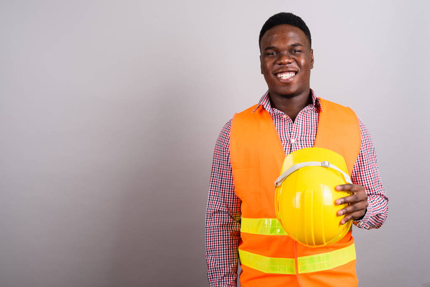 Young African man construction worker against white background - Foto, immagini