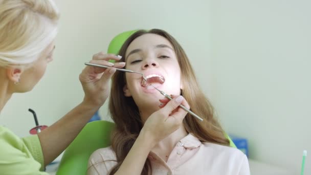 Mujer joven examinándose los dientes en el dentista. Chequeo oral profesional
 - Imágenes, Vídeo