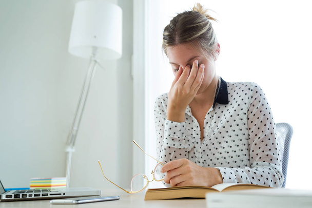 Tiro de excesso de trabalho jovem empresária sofrendo de dor de cabeça e pensando em como terminar o trabalho no escritório
. - Foto, Imagem