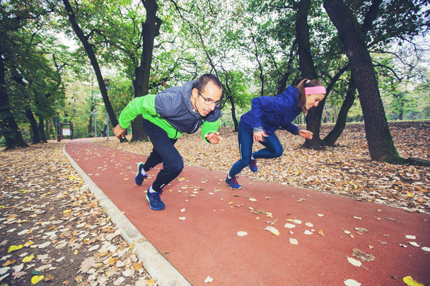 Спортивные мужчина и женщина начинают бегать по фитнес-тропе в лесу
.  - Фото, изображение