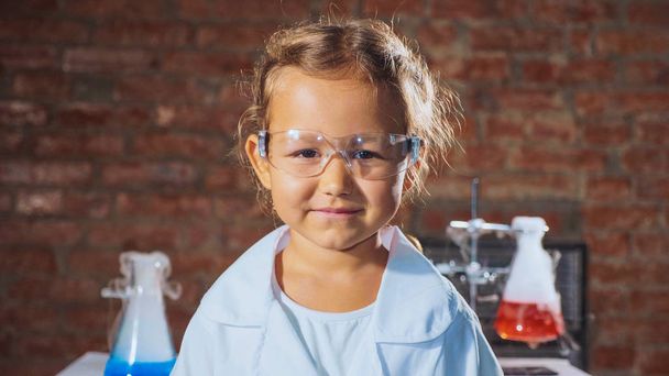 Portrait of a young smiling scientist child girl in a chemistry lab. - Zdjęcie, obraz