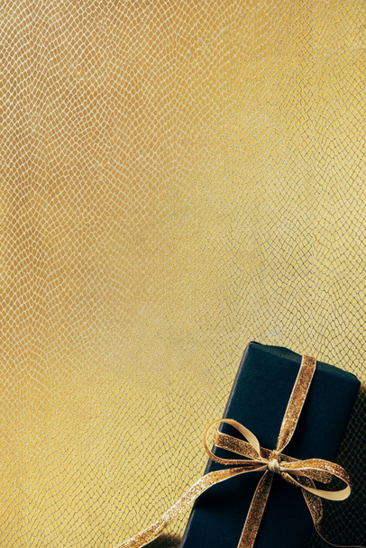 vue du dessus de la boîte cadeau enveloppée avec ruban doré sur fond doré
 - Photo, image