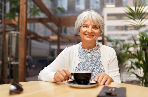 senior woman with coffee at street cafe - Фото, зображення