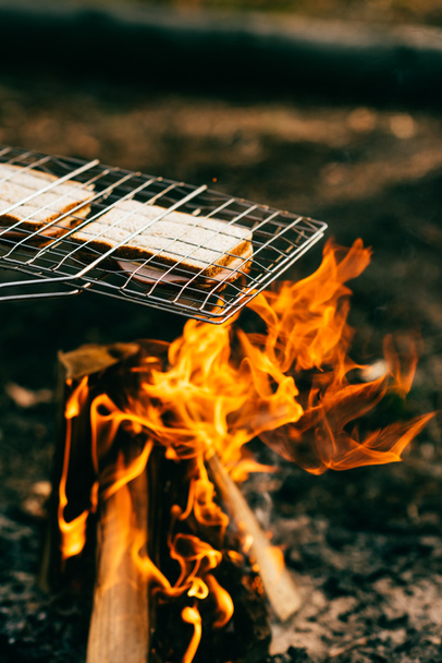 two sandwiches cooking on grill grate over fire - Фото, изображение