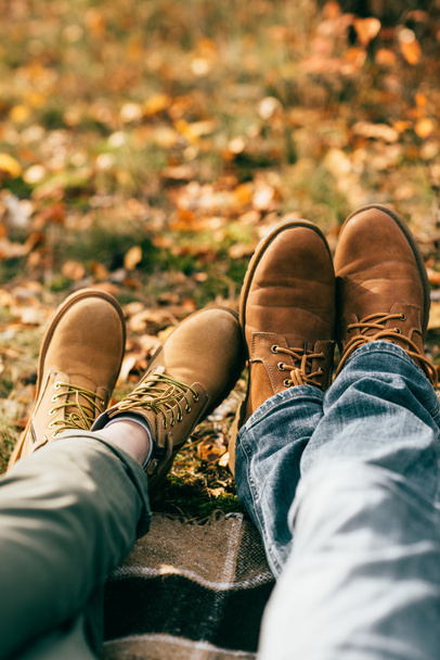 camera point of view on two pairs of orange boots in beautiful foliage in autumn - Photo, Image