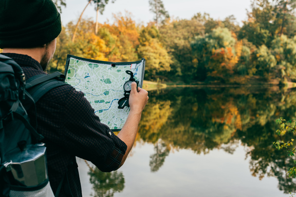 mies matkustava reppu tilalla kartta ja kompassi syksyllä tausta
 - Valokuva, kuva