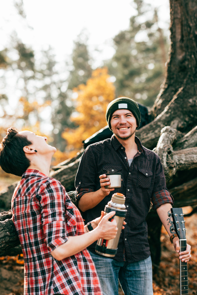 adult couple laughing and having tea on autumal background - Foto, afbeelding