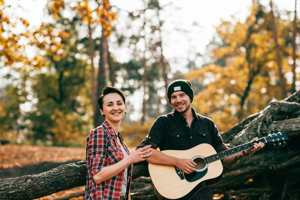 adulte femme et homme s'amuser avec guitare sur fond autumal
 - Photo, image