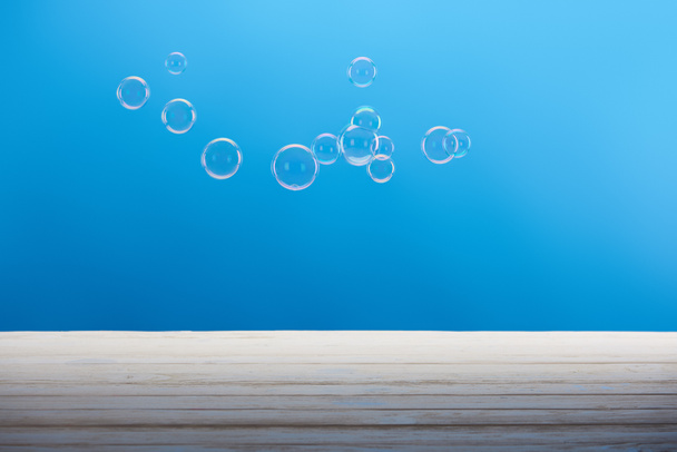clean transparent soap bubbles on blue background  - Foto, afbeelding