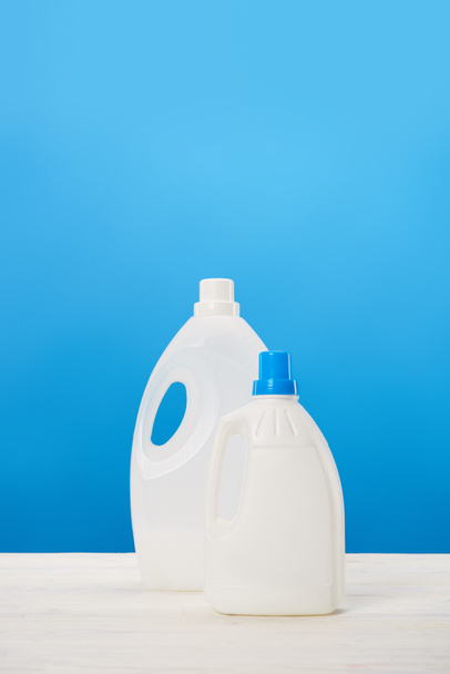 Kunststoffbehälter mit Waschflüssigkeiten auf blau - Foto, Bild