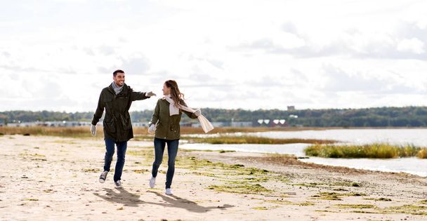 couple running along autumn beach - Photo, Image