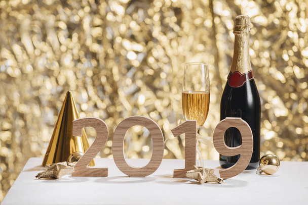 シャンパン グラスとボトルと木製番号 2019 輝く新しい年の背景 - 写真・画像