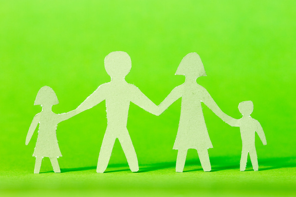 Paper family on green background - Фото, изображение