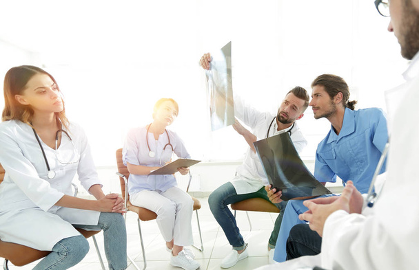 radiologists and a surgeon discussing a radiograph of a patient sitting in the office. - Photo, Image