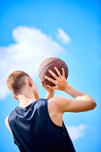 чоловік тримає м'яч під час гри в баскетбол на відкритому повітрі
 - Фото, зображення