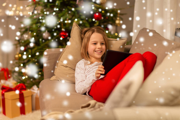 smiling girl with tablet pc at christmas home - Fotoğraf, Görsel