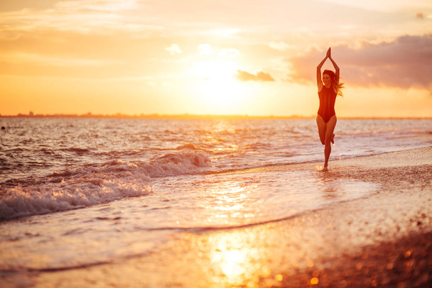 carefree woman dancing in the sunset on the beach. - Foto, Bild