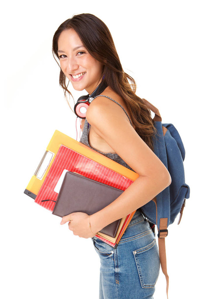 Πλευρά πορτρέτο της χαμογελώντας φοιτήτριας εναντίον απομονωμένων λευκό φόντο με βιβλία και τσάντα - Φωτογραφία, εικόνα