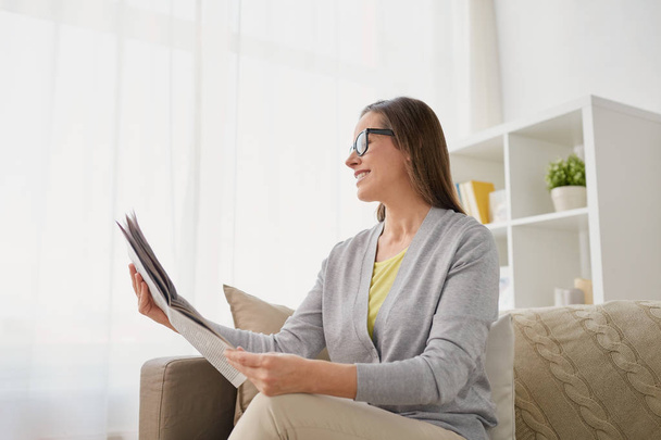 happy woman reading newspaper at home - Foto, Bild