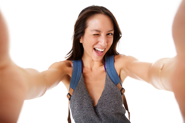 Közelről boldog fiatal ázsiai nő vesz selfie, és hunyorítva szem portréja - Fotó, kép