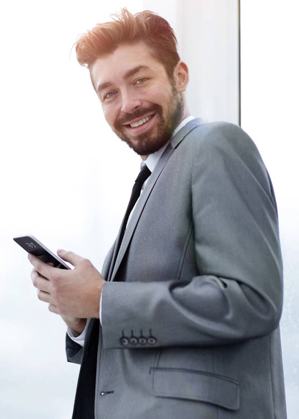 Stylish man in suit is reading information on phone - Fotografie, Obrázek
