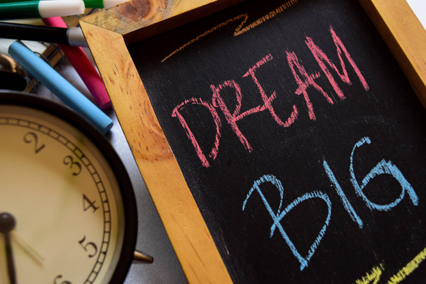 Όνειρο μεγάλο πολύχρωμο φράση χειρόγραφη σε πίνακα κιμωλίας, ρολόι-ξυπνητήρι με έννοιες κινήτρων και εκπαίδευση - Φωτογραφία, εικόνα