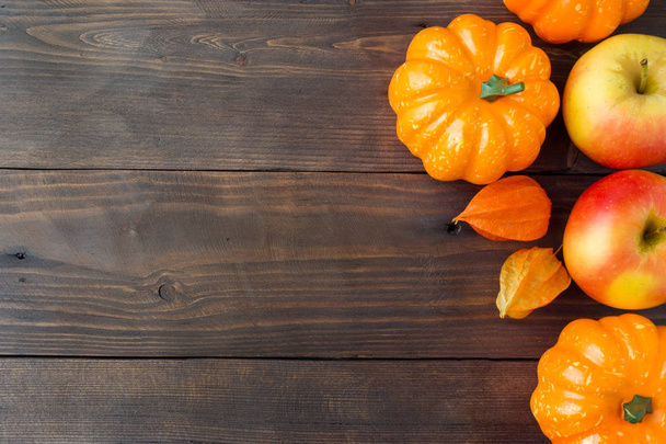 Autumn concept, wooden Background yellow bright pumpkin apples and physalis. Copy space. - 写真・画像