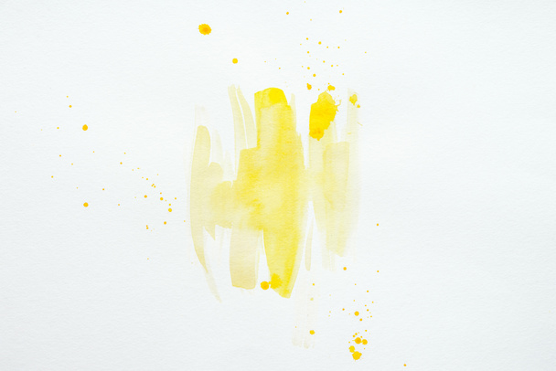 abstrakte gelbe Aquarellspritzer auf weißem Papierhintergrund - Foto, Bild