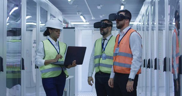 Trabajadores eléctricos en chalecos reflectantes utilizando VR
 - Foto, imagen