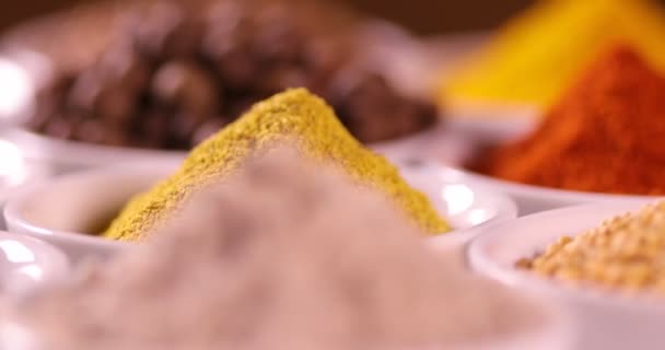 Různé aromatické koření a byliny na kuchyňském stole - Záběry, video