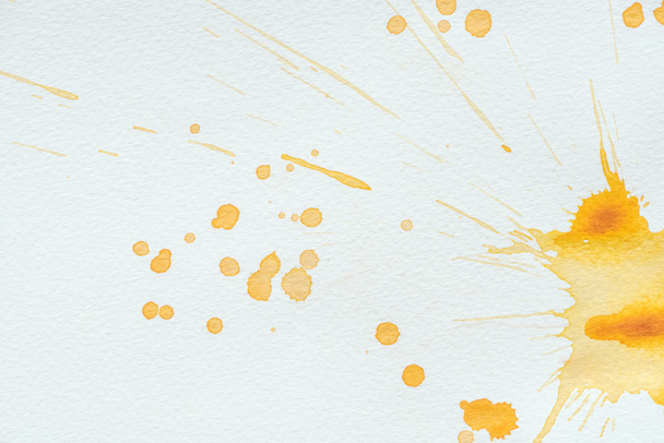 Abstract oranje aquarel splatters en vlekken op wit papier - Foto, afbeelding
