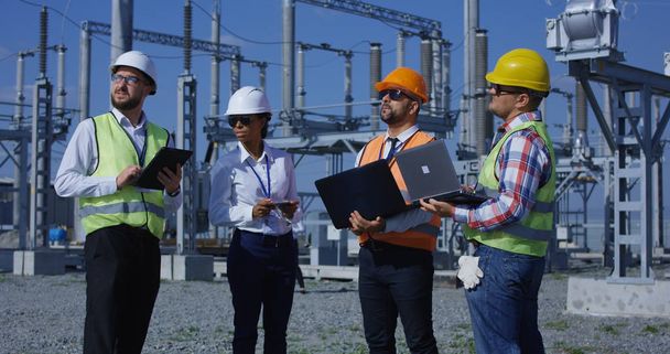 Group of diverse workers on solar plant with gadgets - Photo, Image