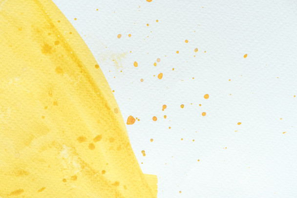abstracte close-up achtergrond met gele aquarel penseelstreek met splatters - Foto, afbeelding