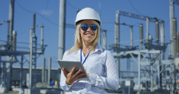 Smiling female electrical worker on a tablet - Photo, Image