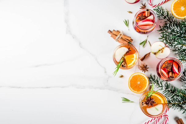 traditionelle Wintergetränke, weißer und roter Glühweincocktail, mit Weiß- und Rotwein, Gewürzen, Apfel, Orange. auf weißem Marmor Hintergrund Kopierraum - Foto, Bild