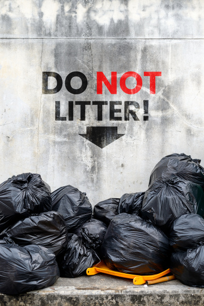 Не мусори. черный мешок для мусора со старым кирпичным фоном
 - Фото, изображение