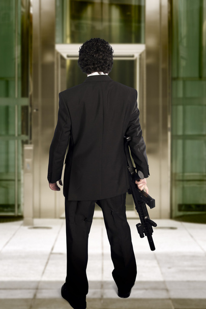 man entering a business building with a machine gun - Fotoğraf, Görsel