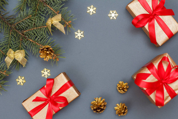 Kerstdecoratie. Geschenkdozen, fir tree takken met kegels op grijze achtergrond. Bovenaanzicht. Christmas wenskaart concept. - Foto, afbeelding
