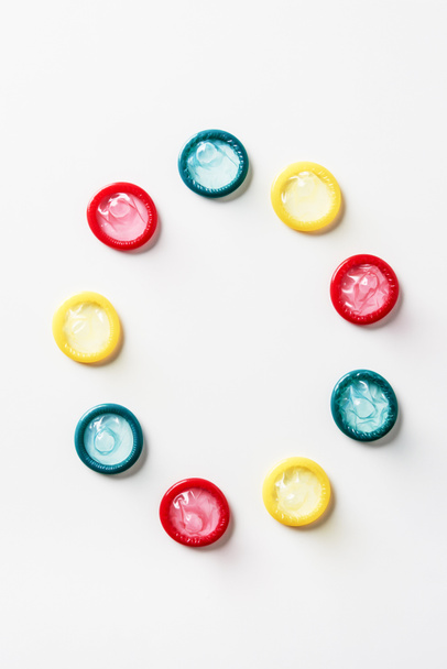 top view of multicolored condoms on white background - Fotoğraf, Görsel