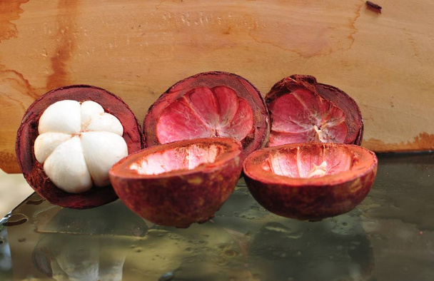  Mangostino fruta, sección transversal que muestra la piel púrpura gruesa, reina de las frutas
. - Foto, imagen