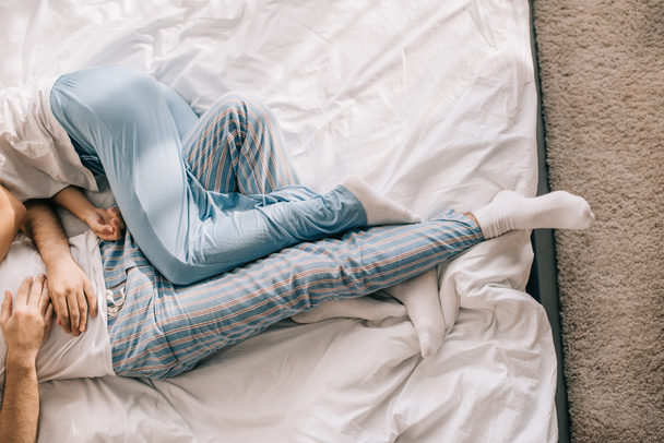 cropped shot of couple in pajamas sleeping in bed in morning - Foto, Imagen