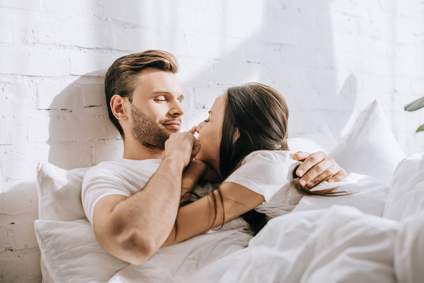 happy young couple relaxing in bed together - Photo, Image