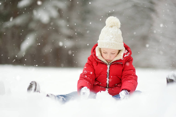 Adorable little girl having fun in beautiful winter park - 写真・画像